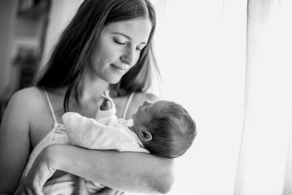 Maman qui contemple son nouveau-né, en noir et blanc