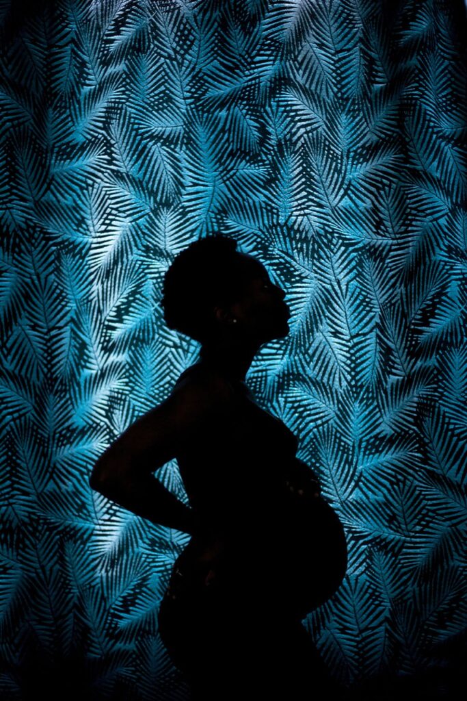 Silhouette d'une femme enceinte sur fond bleu