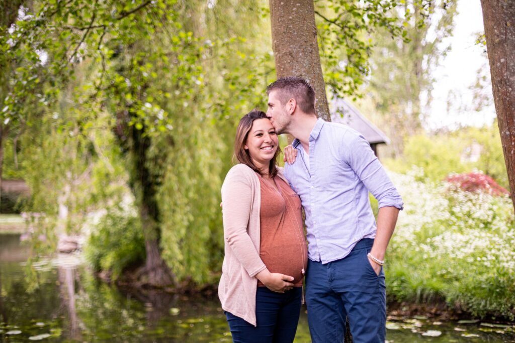 Futurs parents qui s'embrassent dans un jardin