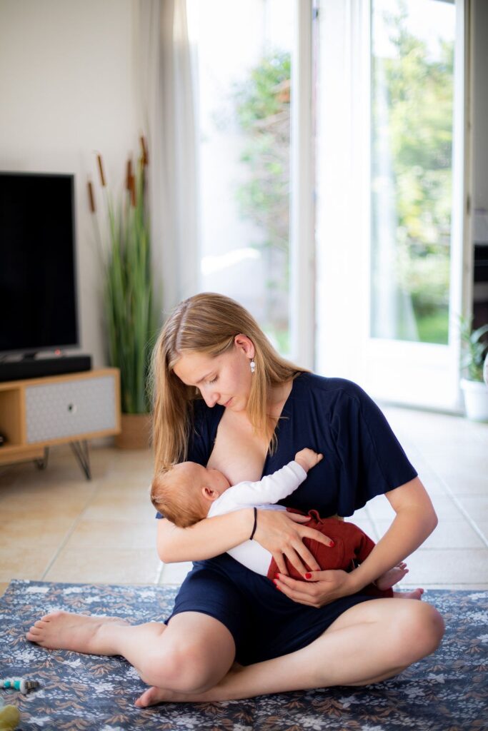 Maman qui allaite son bébé dans le salon