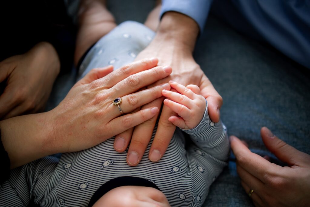 Mains d'un papa, d'une maman et de leur bébé réunies