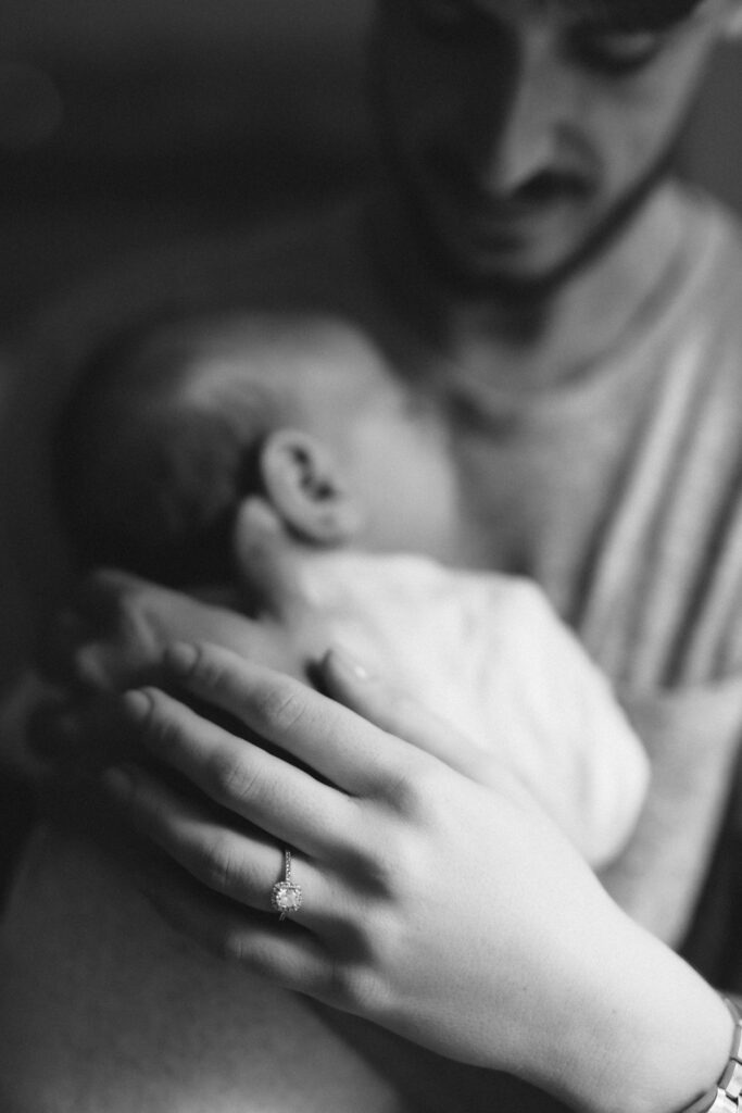Nouveau-né blotti contre sa maman, en noir et blanc