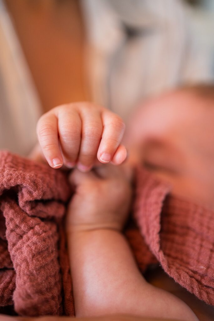 Mains d'enfant sur un pull rouge, gros plan