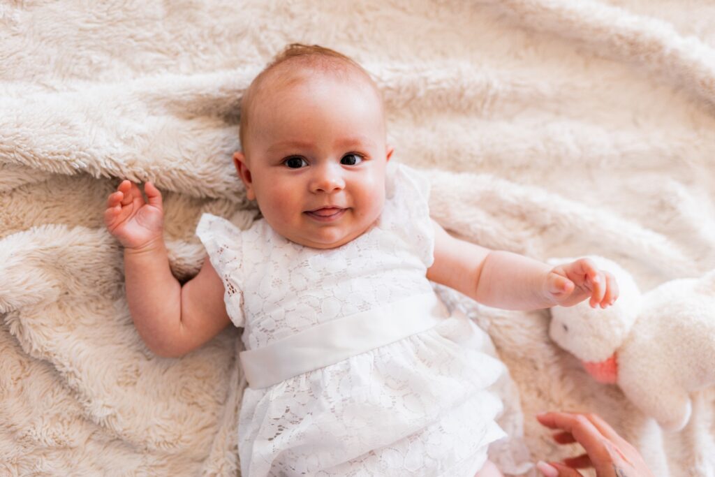 Bébé souriant en robe blanche